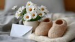 © Yanina - Pregnancy announcement concept with knitted baby booties, white daisies and a blank card envelope