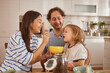 © Stockphotodirectors - A family shares a delightful breakfast moment in their stylish kitchen. The parents feed their child with smiles, creating happy memories together.
