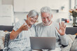 © Daniel - Cheerful mature married family couple talking on video call on laptop, watching funny movie with internet media TV service, enjoying leisure on couch with gadget, relaxing at home, laughing
