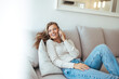 © Dragana Gordic - Smiling Woman Relaxing on Couch Talking on Phone at Home, Casual Leisure Scene, Lifestyle, Bright