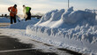 © val_webart - Two men shoveling snow in a parking lot during winter daylight