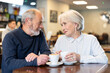 © JackF - Couple of elderly man and woman chatting and drinking coffee at table in cafe