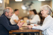 © JackF - Joyful elderly couple on a date in a cozy coffee shop, they have a nice conversation and discuss joint plans.