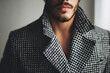 © lemonmoon - Confident man showcases intricate houndstooth fabric detail on his stylish winter coat highlighting sophisticated pattern and refined texture of garment