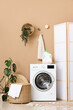 © Pixel-Shot - Interior of laundry room with modern washing machine near brown wall