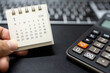 © Wongsakorn - Hand holding January 2026 calendar with calculator for financial stress and budget crisis concept. financial anxiety, calculating monthly expenses, debt management.
