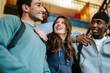 © Maskot - Low angle view of happy female student spending leisure time with male friends in college campus