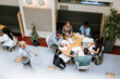 © Maskot - High angle view of male and female adult students studying with each other while sitting in college campus