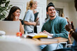 © Maskot - Multiracial male and female student sitting for group studies in university campus
