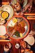 © Maskot - Directly above shot of fresh Ethiopian dish amidst drinks on table at fine dining restaurant