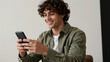 © utaem2022 - Young man smiling and texting with mobile phone