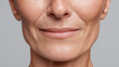 © Marut - Close up with soft light showing minor skin texture damage on mature woman face with natural wrinkles and smooth lips smiling gently