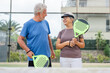 © Daniel - Portrait of couple of mature people playing padel game outdoors in a paddle tennis court together. Old man embracing mature woman teammate