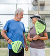 © Daniel - Portrait of couple of mature people playing padel game outdoors in a paddle tennis court together. Old man embracing mature woman teammate