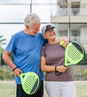 © Daniel - Portrait of couple of mature people playing padel game outdoors in a paddle tennis court together. Old man embracing mature woman teammate