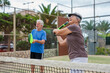 © Daniel - Portrait of couple of mature people playing padel game outdoors in a paddle tennis court together. Old man and mature woman teammate having fun enjoying