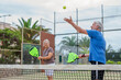 © Daniel - Portrait of couple of mature people playing padel game outdoors in a paddle tennis court together. Old man and mature woman teammate having fun enjoying