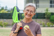 © Daniel - One old mature senior woman in padel court outdoors looking at the camera having fun holding paddle tennis racquet smiling and enjoying after game