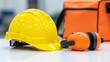 © Rima Akter - Essential personal protective equipment: a yellow hard hat and orange ear defenders for workplace safety