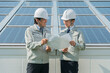© buritora - A technician in work clothes from an electric power company or electrical contractor standing in front of a solar panel (clean energy)