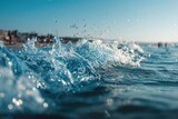 Water splashes and waves crash on a beach at sunset