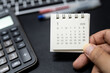 © Wongsakorn - Hand holding January 2026 calendar with calculator for financial stress and budget crisis concept. financial anxiety, calculating monthly expenses, debt management.
