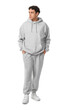 © Pixel-Shot - Young man in grey sports suit on white background