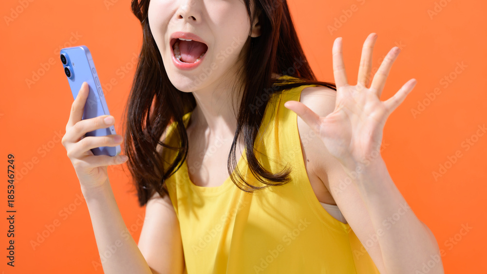 スマホを持って驚く女性