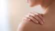 © Nakarin - Close up of hands gently massaging shoulder with smooth skin in soft natural light for relaxation and care