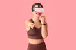 © Pixel-Shot - Sporty young woman in modern VR glasses exercising on pink background