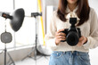 © Pixel-Shot - Female photographer with camera in photo studio, closeup