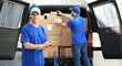 © Pixel-Shot - Delivery men taking parcels from car outdoors
