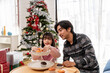 © Kawee - Asian father and daughter prepare desserts during Christmas celebration.