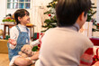 © Kawee - Asian young siblings opening present gift boxes under Christmas tree.
