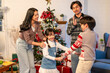 © Kawee - Lovely Asian family celebrating Christmas party together at cozy home.