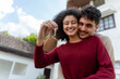 © Kawee - Portrait of Latina couple holding a key and small wooden house model.