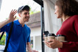 © Kawee - Latino delivery man in blue uniform bringing drinks to customer at home.