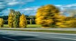 © Arkan - Blurry autumn trees along a road with a dynamic, motion-filled sky