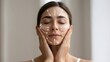 © TensorSpark - Woman performing face yoga massage with marked facial lines, demonstrating lifting and sculpting technique for skin and muscle tone.