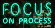 © antishock - Bright neon sign displays text. Words focus on process glow vividly against dark background. Simple, motivational message.