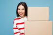 © ViDi Studio - Young smiling woman she wear red striped sweatshirt casual clothes hold stack of two blank cardboard boxes look camera isolated on plain pastel light blue background studio portrait Lifestyle concept