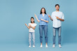 © ViDi Studio - Full body young happy parents mom dad with child kid daughter girl wearing casual clothes point index finger aside on blank empty area isolated on plain blue background. Family day childhood concept.