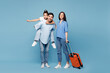 © ViDi Studio - Traveler young fun parents mom dad child wear casual clothes hold suitcase bag isolated on plain blue background. Tourist travel abroad in free spare time rest getaway Air flight trip journey concept