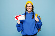 © ViDi Studio - Young smart woman student she wear casual clothes backpack bag hold gift certificate coupon voucher card for store isolated on pastel plain light blue color background. High college lifestyle concept.