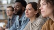 © CYBERPINK - Group of four young people sitting in a row, looking off into the distance. they appear to be in a classroom or a similar setting, with a bookshelf visible in the background.