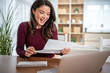 © Migma_Agency - Happy woman receiving good news letter at home