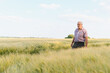 © Serhii - Senior farmer walking and inspecting wheat field at sunset