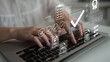 © InfiniteFlow - A close-up view of hands typing on a laptop keyboard surrounded by digital icons and checkmarks, symbolizing productivity and successful task management in a contemporary office. Gantry