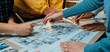 © InfiniteFlow - A collaborative design session where a diverse group engages with sketches and blueprints on a table, showcasing teamwork and innovative planning in an inspiring workspace. SACTR