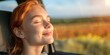 © Orod - Happy redhead woman enjoying fresh air and sunset breeze from car window.